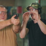 A man learns how to shoot a gun at the shooting range.