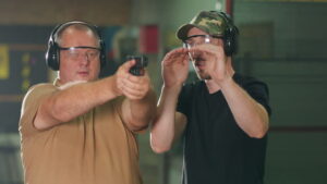 A man learns how to shoot a gun at the shooting range.